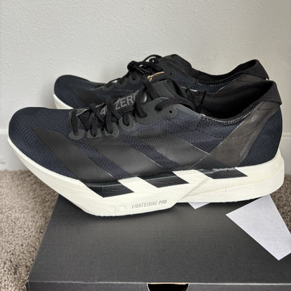 The Adidas Adizero Adios Pro 4 in Core Black and Grey Five features a lightweight mesh upper paired with high-performance Lightstrike Pro cushioning