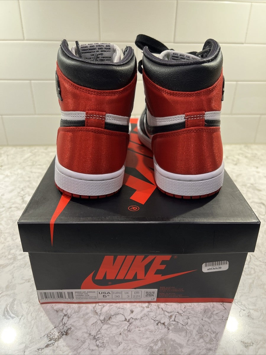 Jordan 1 Retro High OG 'Satin Black Toe', showcasing a lustrous red