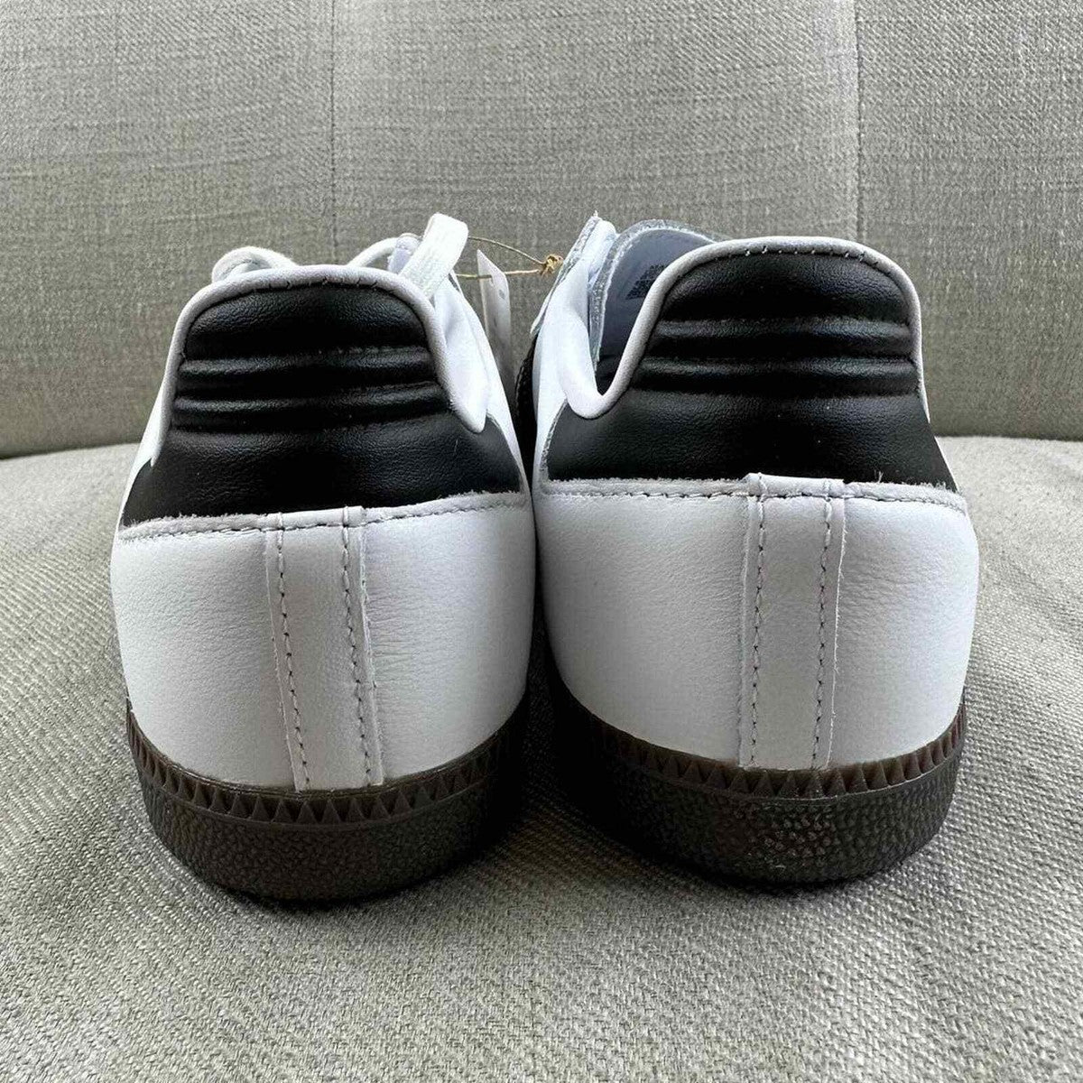 The Adidas Originals Samba OG sneaker features a crisp white leather upper accented by black serrated three-stripes and a classic translucent gum rubber sole