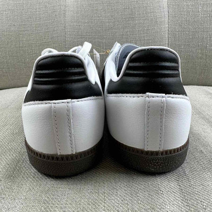 The Adidas Originals Samba OG sneaker features a crisp white leather upper accented by black serrated three-stripes and a classic translucent gum rubber sole