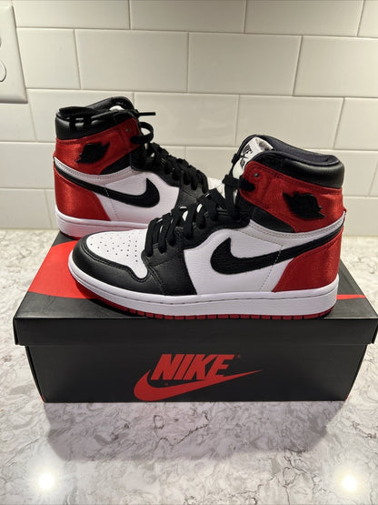 Jordan 1 Retro High OG 'Satin Black Toe', showcasing a lustrous red