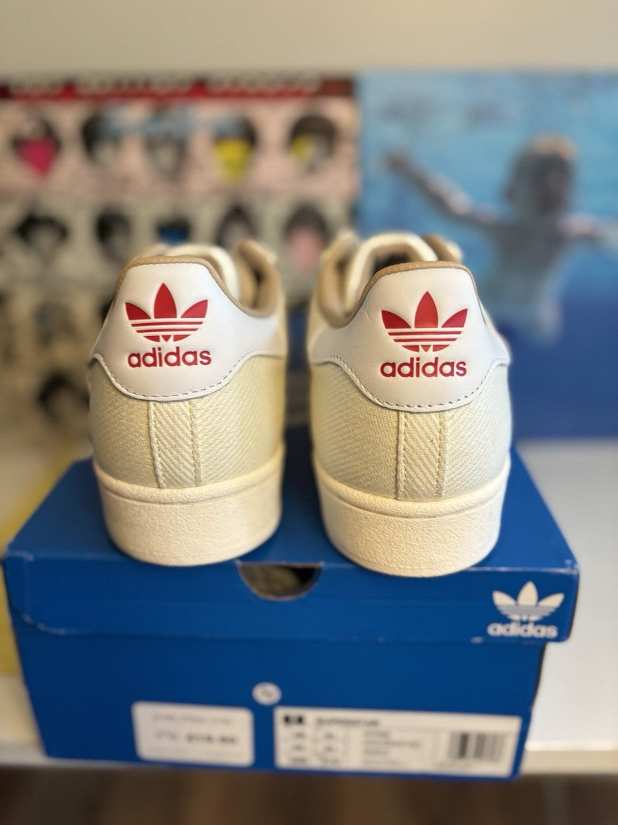 Adidas Superstar, distinguished by its textured fabric upper and red side lettering