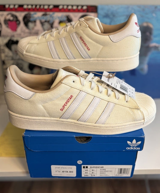 Adidas Superstar, distinguished by its textured fabric upper and red side lettering